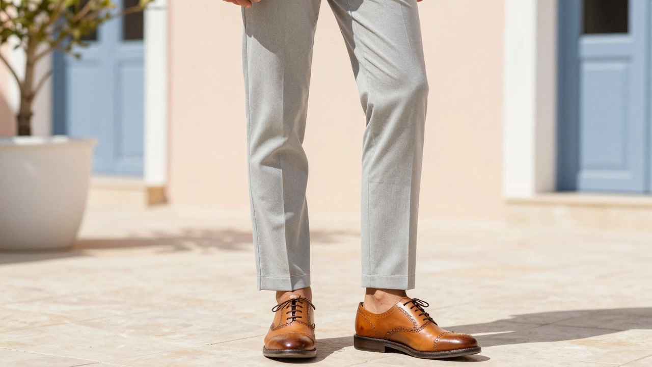 Close-up of light grey suit trousers paired with tan leather brogue shoes.